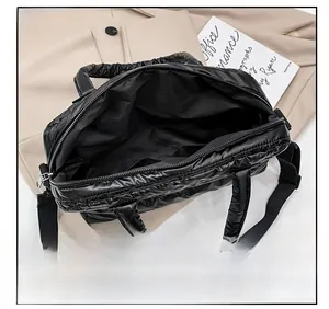 Top view of quilted black down bag showing main zipper and spacious inner compartment