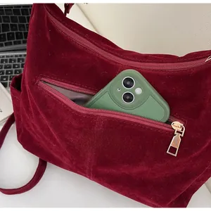 Detail of burgundy velvet tote bag with zipper pocket showing large capacity for smartphones