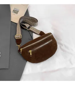 Detail of dark brown suede fanny pack with golden zippers and ethnic jacquard strap