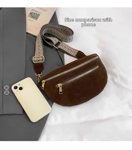 Detail of dark brown suede saddle bag with patterned strap compared to a smartphone