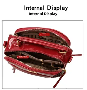 Vue détaillée du sac en cuir verni rouge avec deux compartiments zippés et doublure rayée