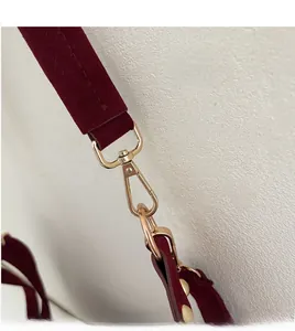 Detail of burgundy suede shoulder strap with durable golden swivel metal hook closure