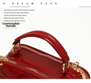 Détail du sac à main en cuir verni rouge avec ferrures dorées et poignée supérieure