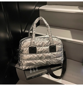 Close-up of metallic silver puffer gym bag featuring quilted texture and black nylon straps