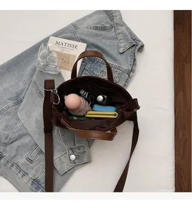 Detail view of large capacity dark brown suede tote showing interior space for daily items