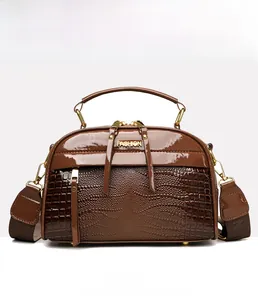 Détail du cuir croco marron avec poignées dorées et plaque métallique de mode