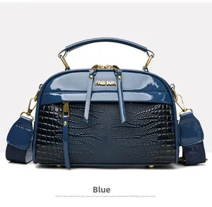 Détail du sac bleu en cuir texturé avec poignées dorées et double fermeture