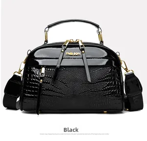 Détail d'un sac à main noir en cuir crocodile avec inscription fashion dorée