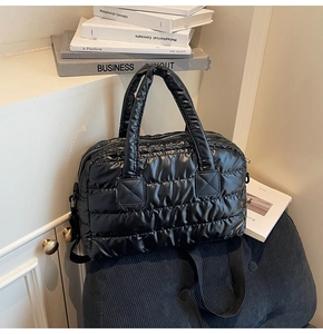 Detail of a black quilted fitness bag featuring soft puffy nylon and a sturdy zipper