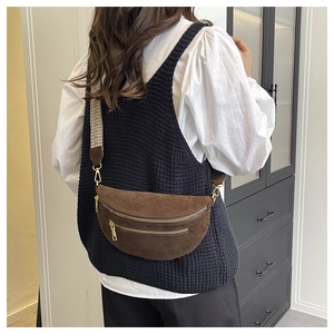 Detailed view of brown suede crossbody saddle bag with geometric wide strap and gold hardware