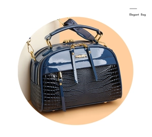 Détail du sac bandoulière bleu marine avec texture crocodile et garnitures dorées