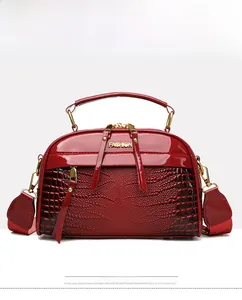 Détails d'un sac à main en cuir verni rouge à motif crocodile et finitions dorées