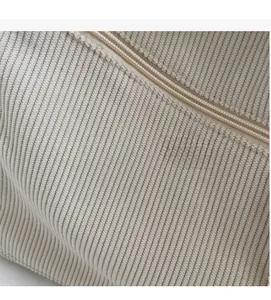 Detailed macro view of cream corduroy fabric texture and matching zipper closure