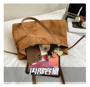 Vue détaillée du grand sac cabas en daim marron avec fermeture magnétique pour le quotidien