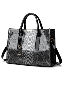 Detail van de slangenprint textuur en goudkleurige hardware op deze dames handtas