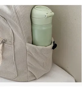 Detail of corduroy tote bag side pocket holding a water bottle for storage display