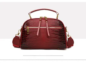 Détails du sac à main rouge en cuir croco avec bandoulière large et finitions dorées