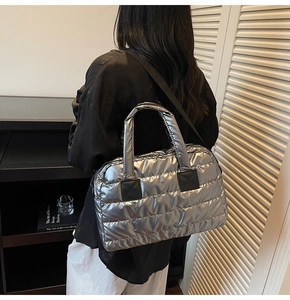 Sac fourre-tout matelassé argenté porté par un mannequin avec bandoulière réglable