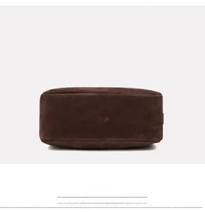 Detailed bottom view of a dark brown suede crossbody bag showing square base texture