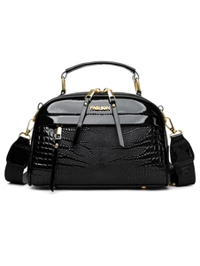 Détail du sac noir avec texture crocodile, logo métallique doré et bandoulière large