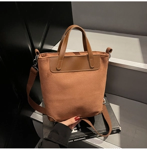 Dettaglio borsa tote in pelle scamosciata marrone con angoli rinforzati e tracolla