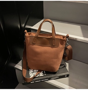 Dettaglio della borsa tote in pelle scamosciata caramello con angoli rinforzati e tracolla