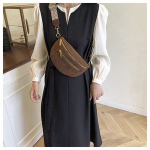 Brown suede crossbody saddle bag with golden zipper and geometric pattern wide strap