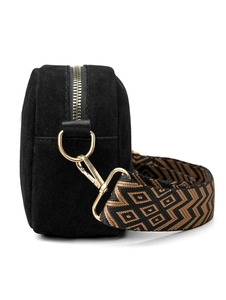 Detail view of black suede crossbody bag showing gold zipper and jacquard geometric strap