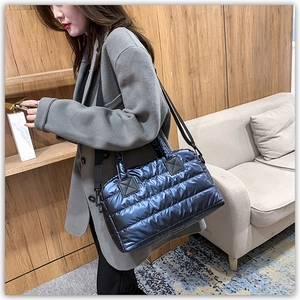 Detail of glossy navy quilted tote bag with detachable strap for daily commuting
