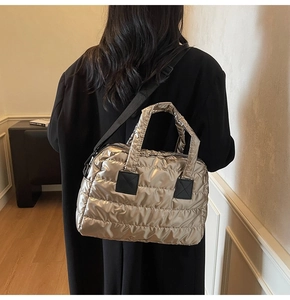 Detail of metallic quilted fitness bag showing glossy finish and adjustable nylon strap