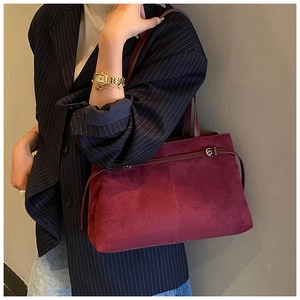 Détail d'un cabas en daim bordeaux avec brides élégantes et finition texturée chic
