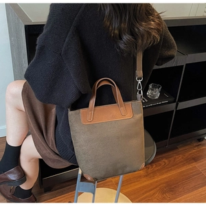 Dettaglio della borsa retrò in pelle scamosciata con manici in pelle marrone e tracolla
