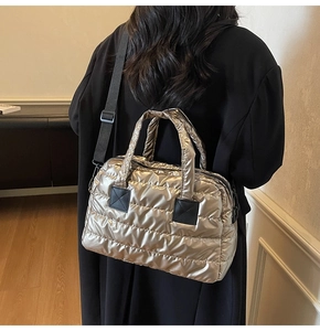 Quilted metallic yoga bag in champagne gold shown on a model with adjustable strap