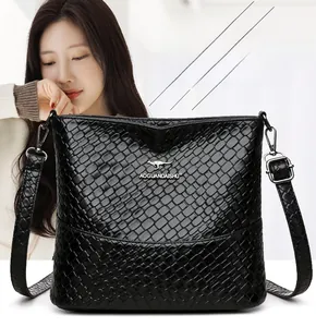 Close-up of black woven bucket bag showing textured leather and silver zipper detail