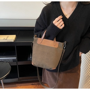 Dettaglio borsa vintage in pelle scamosciata con manici in pelle e tracolla rimovibile