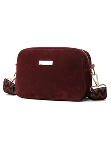 Detail of burgundy suede crossbody bag featuring golden hardware and woven strap