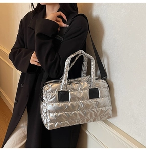 Détail du sac cabas matelassé argenté avec bretelles noires contrastées et fini brillant