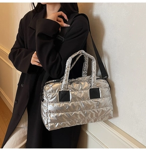 Detail of silver metallic quilted fitness bag with black strap and soft padded texture