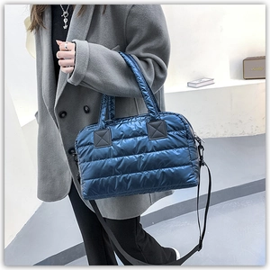 Detail of navy quilted tote with satin finish and adjustable shoulder strap
