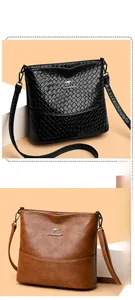 Detail of elegant bucket bags in black croc-embossed and smooth brown leather finishes