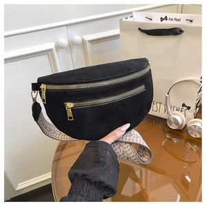 Detail of black suede saddle bag with dual gold zippers and vintage woven strap