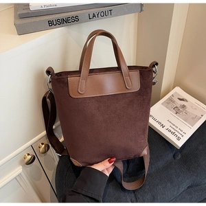 Dettaglio di una borsa tote in pelle scamosciata marrone con manici in finta pelle