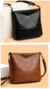 Detail of black snake pattern and brown leather handbags with metallic kangaroo logo