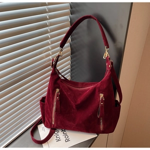 Detailed close-up of burgundy frosted tote bag with gold zippers and shadow play