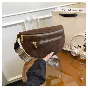 Detail of dark brown matte saddle bag with ethnic pattern wide strap and gold zippers