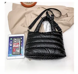 Détail du sac cabas matelassé noir brillant avec bandoulière réglable pour le quotidien