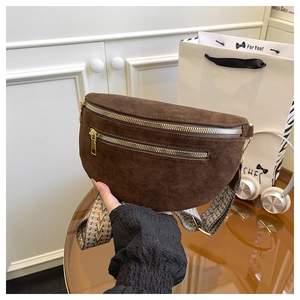Detail of dark brown suede fanny pack with dual gold zippers and ethnic woven strap