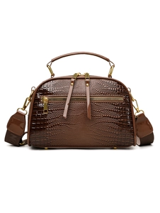 Détail du sac Boston marron foncé avec texture crocodile et fermetures éclair dorées