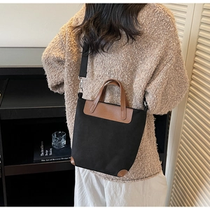 Dettaglio della borsa tote vintage in tela con manici in pelle marrone e tracolla regolabile
