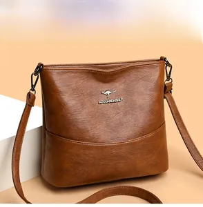 Close-up of brown vintage leather tote bag with silver metal kangaroo logo and strap detail
